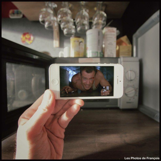 Movie and TV scenes on an iPhone held up in front of perfect real-life backgrounds 1