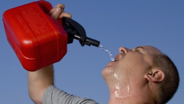 A man drinking gasoline from a gas can.