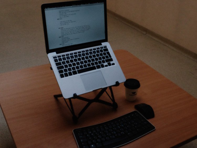 Roost laptop stand on desk with keyboard and mouse sideways on