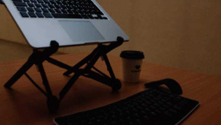 Roost laptop stand on desk with keyboard and mouse close up